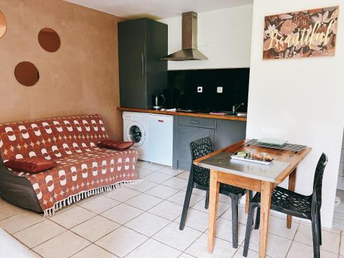 une cuisine et un salon avec une table et un canapé dans l'établissement CASAMACCE Studio climatisé avec terrasse, small comfortable apartment free parking, air-conditioned & Wifi, à Corte