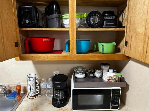 eine Küchentheke mit einer Mikrowelle und anderen Küchenutensilien in der Unterkunft Eagle Stay 7 Condo in Eagle Pass