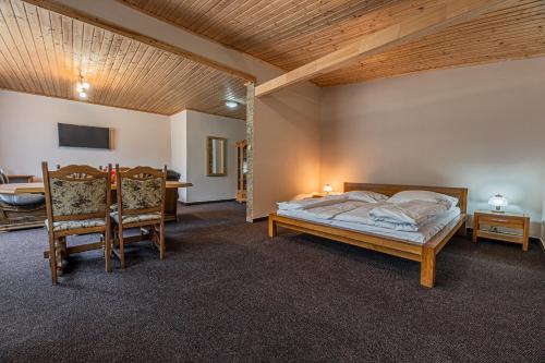 een slaapkamer met een bed en een tafel en stoelen bij Grand Hotel rooms in Spišské Tomášovce