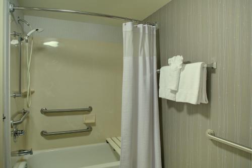 a bathroom with a shower and a white shower curtain at Courtyard Richmond Chester in Chester