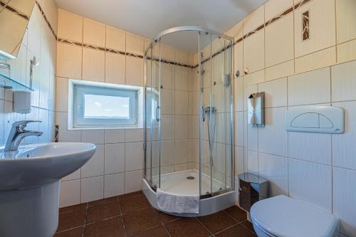 een badkamer met een douche, een toilet en een wastafel bij Grand Hotel rooms in Spišské Tomášovce