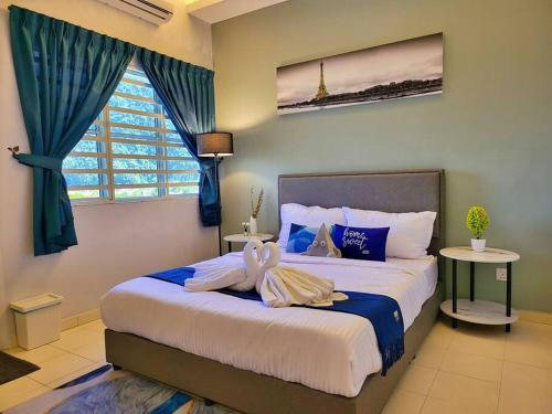 a bedroom with a large bed with towels on it at Sunway Cozy Apartment near Lost World of Tambun in Ipoh