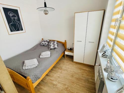 niewielka sypialnia z łóżkiem i szafką w obiekcie Mazury Szczytno - Apartamenty u Krzyżaka - Centrum w mieście Szczytno