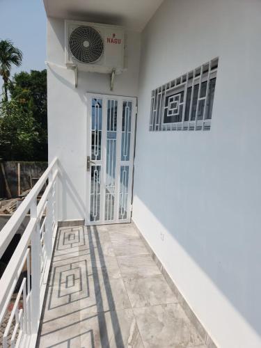 a white house with a door and a fan at Magnifique Appartement Meublé Douala Kotto avec Groupe Electrogène et WiFi, Calme et Securisé in Douala