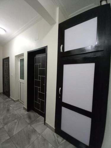 a room with a black door and a white wall at Magnifique Appartement Meublé Douala Kotto avec Groupe Electrogène et WiFi, Calme et Securisé in Douala