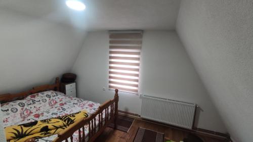 a small bedroom with a bed and a window at Vikendica Vrtača- Odvraćenica in Novi Pazar