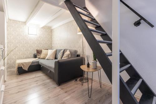 a living room with a bed and a staircase at Urban Oasis Apartment in Budapest