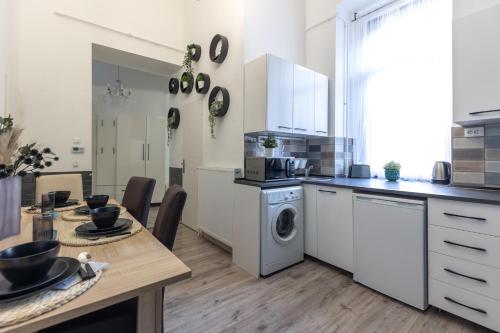 a kitchen with a table and a washing machine at Urban Oasis Apartment in Budapest