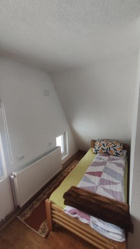 a small bedroom with a bed in a attic at Vikendica Vrtača- Odvraćenica in Novi Pazar