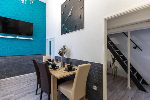 a dining room with a table and a clock on the wall at Urban Oasis Apartment in Budapest