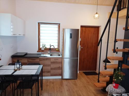 a kitchen with a stainless steel refrigerator and a table at Domek u Gołąbków Bieszczady in Lesko