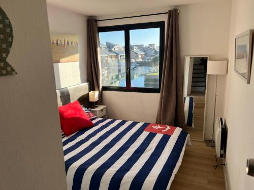 une chambre avec un lit et une grande fenêtre dans l'établissement Refuge des pirates, à Deauville