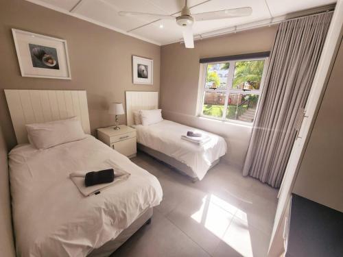 a bedroom with two beds and a window at Caribbean Estates-Montego Bay 12 in Port Edward