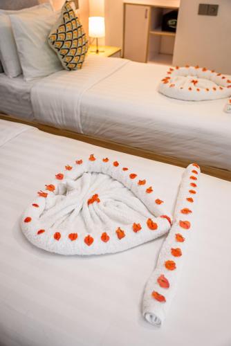 two beds with a cake on top of them at Holiday Crib in Dhiffushi