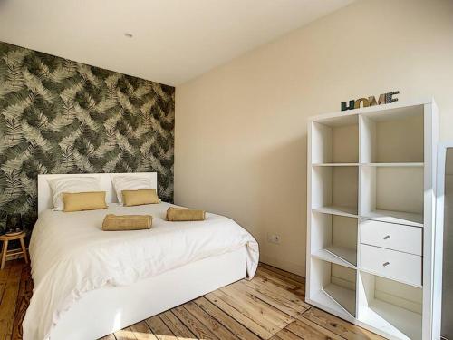 a bedroom with a white bed and a book shelf at [L'ABBAT-JOUR] L'émeraude • Plein Sud • Thermes in Bagnères-de-Bigorre