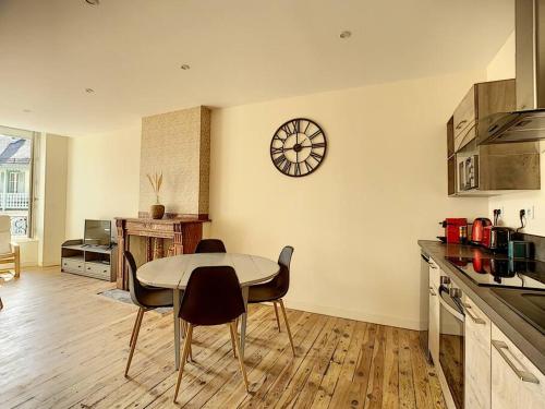 une cuisine avec une table et des chaises et une horloge au mur dans l'établissement [L'ABBAT-JOUR] L'émeraude • Plein Sud • Thermes, à Bagnères-de-Bigorre