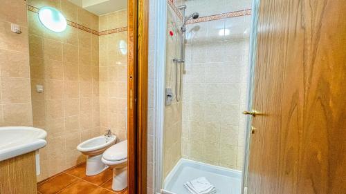 uma casa de banho com um chuveiro, um WC e um lavatório. em Appartamento Smith Bonarda - Affitti Brevi Italia em Bardonecchia