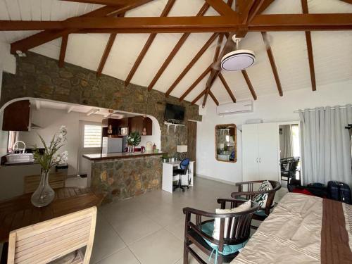 a kitchen and living room with a stone wall at Studio Colline Nettle in Marigot