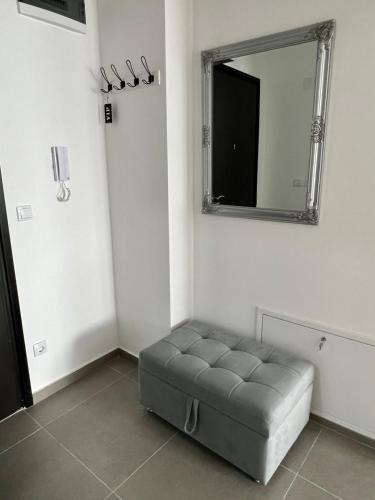 a room with a tufted ottoman and a mirror at Wolf Gray apartman Sarajevo in Sarajevo