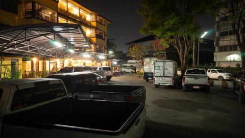 a bunch of cars parked in a parking lot at night at Trithana Boutique House in Chiang Mai