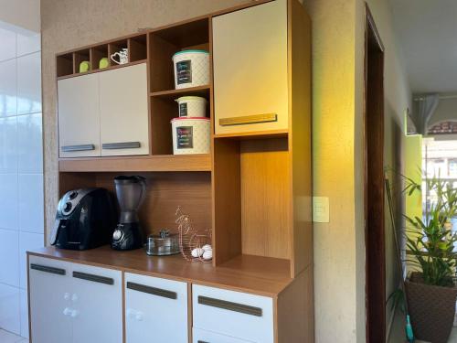 a kitchen with wooden shelves and white cabinets at Casa ao lado do centro in Itabira