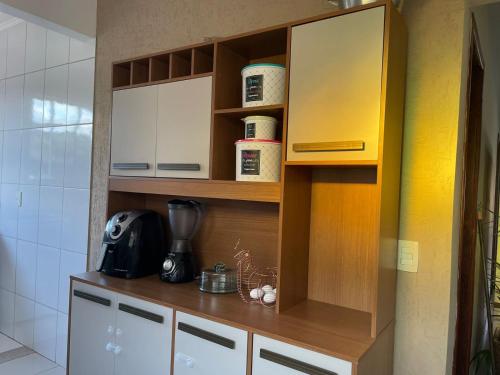 een keuken met witte kasten en een aanrechtblad bij Casa ao lado do centro in Itabira