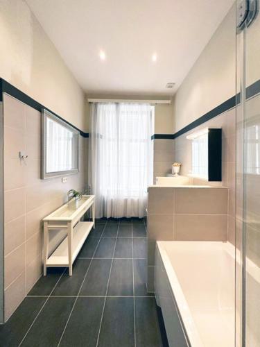 a bathroom with a shower and a sink and a tub at Wienerwald Residenz in Baden