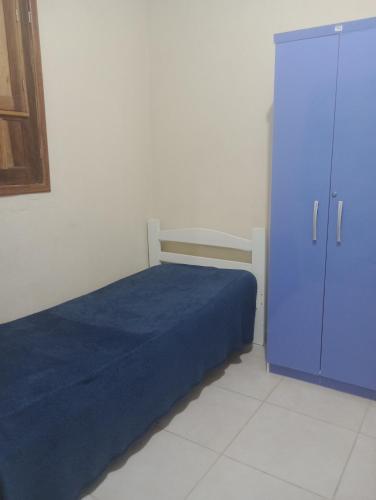 a bedroom with a blue bed and a cabinet at Mar doce lar in Cabo de Santo Agostinho