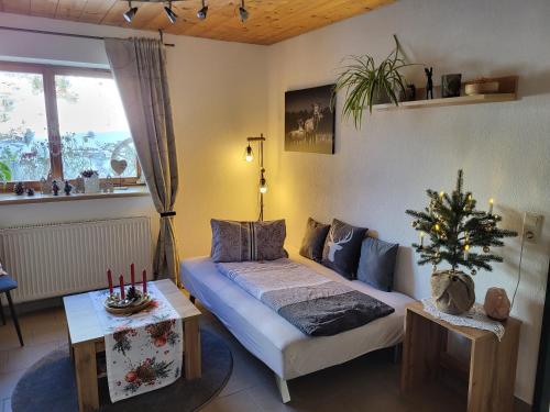 een woonkamer met een bed en een kerstboom bij Bergbauernhof-Grinzens in Grinzens