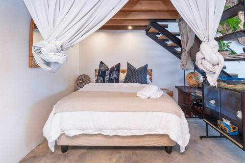 a bedroom with a large bed with blue pillows at The Old Shop Loft apt in the heart of the village in Cape Town