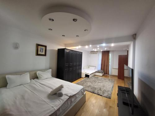 a bedroom with a large white bed and a room with at Open Space Apartment National Arena Monza in Colonişti