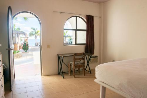 - une chambre avec un lit, un bureau et une fenêtre dans l'établissement La Ventana Beach Resort, à La Paz