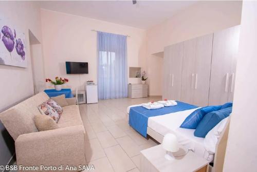 a bedroom with a blue bed and a couch at Bed and Breakfast Port View in Civitavecchia