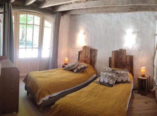 - 2 lits dans une chambre avec 2 lampes et une fenêtre dans l'établissement Le cottage des Acacias, à Salignac Eyvigues