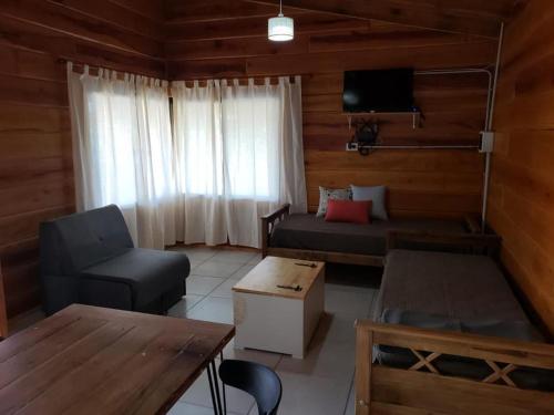 a living room with a couch and a table at Cabañas Puesta del Sol in Villa Yacanto
