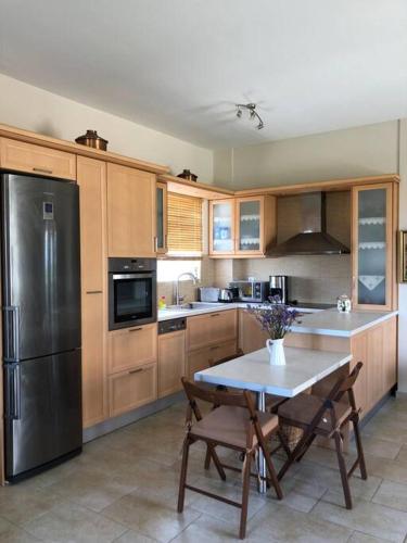 eine Küche mit einem Tisch und einem Kühlschrank aus Edelstahl in der Unterkunft Elegant Maisonette 