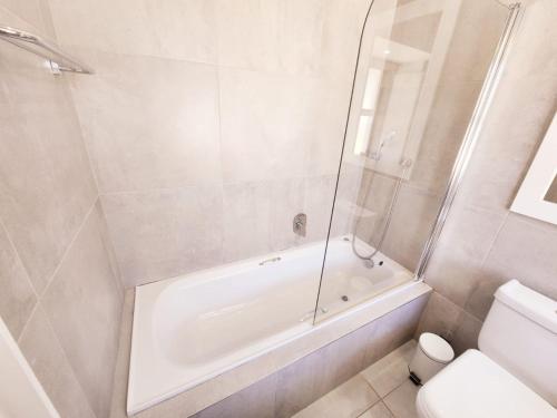 La salle de bains blanche est pourvue d'une baignoire et de toilettes. dans l'établissement Caribbean Estates-Montego Bay 12, à Port Edward