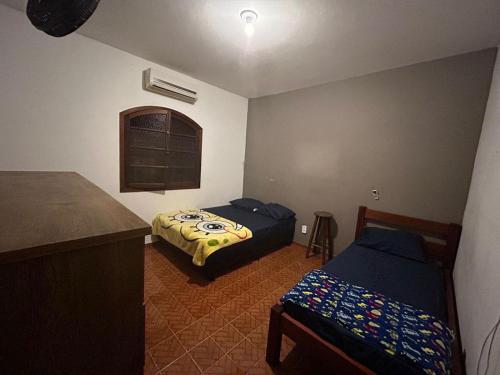 Cette petite chambre comprend 2 lits et un comptoir. dans l'établissement Casa na praia, à Bertioga