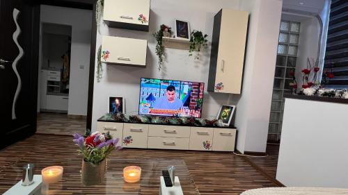 - un salon avec une télévision et une table dans l'établissement Apartament ultramodern cu 2 camere, à Onești