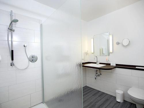 a white bathroom with a shower and a toilet at Thöles*** Am Allerpark Verden in Verden