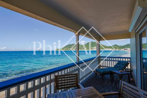 a porch with two chairs and the ocean at Magnifique 3 pièces à Gd Case Les pieds dans l'eau in Grand Case