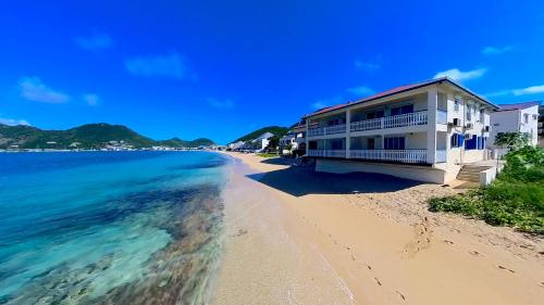 a building on a beach next to the ocean at Magnifique 3 pièces à Gd Case Les pieds dans l'eau in Grand Case