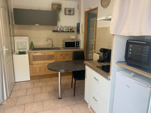une petite cuisine avec une table et un micro-ondes dans l'établissement Studio décoré avec goût, à Saint-Paul-Trois-Châteaux