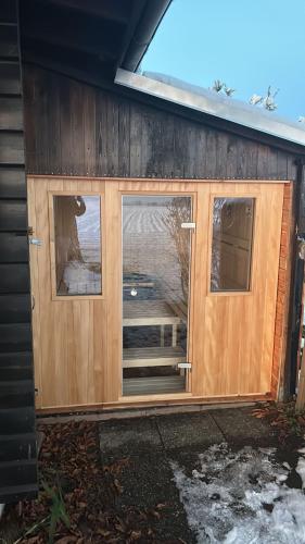 a wooden door with two windows on a house at Chalet am Feldrand in Starzach