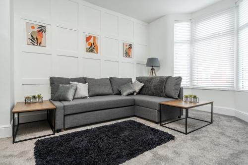 Sala de estar con sofá gris y 2 mesas en Harrow Lodge - Anfield Apartments en Liverpool