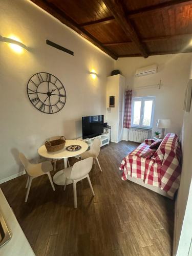 a living room with a table and a clock on the wall at Dolce vita al lago in Anguillara Sabazia
