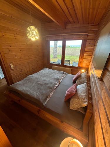 um quarto com uma cama num chalé de madeira em Chalet am Feldrand em Starzach
