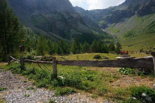 a wooden fence in a field with mountains in the background at bnb Valais - by La Sittelle in Grimisuat