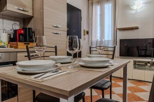 una mesa de madera con platos y copas de vino. en [City Center] Comfort and Relax, en Rovigo
