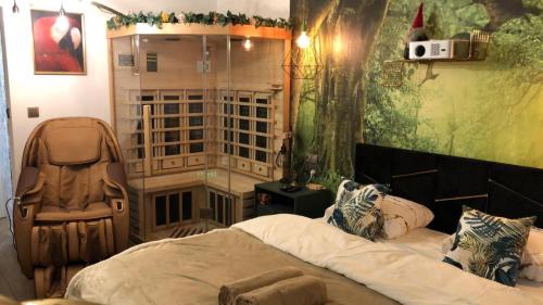 a bedroom with a large bed and a chair at WARSZAWA WOLA Wyjątkowe Studio z Jacuzzi, Sauną i Fotelem do Masażu - Exceptional Studio in Warsaw with Jacuzzi, Sauna and Massage Chair in Warsaw